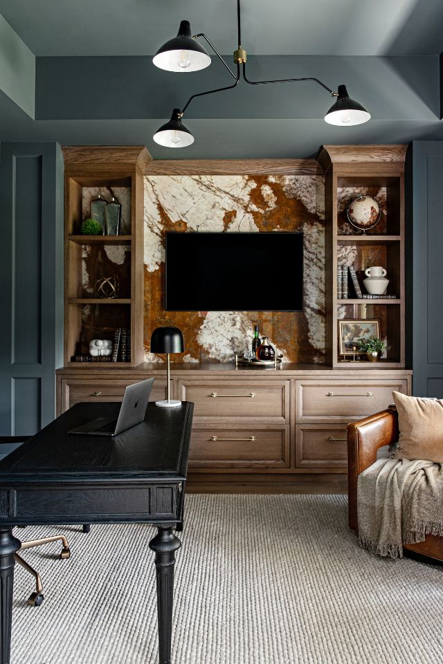 designer study with feature wall behind tv and black metal finishes